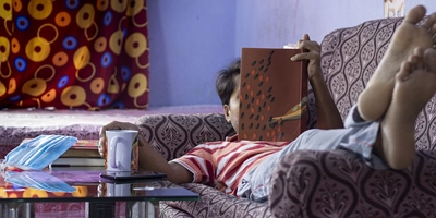 Foto di Uomo disteso sul divano che legge un libro