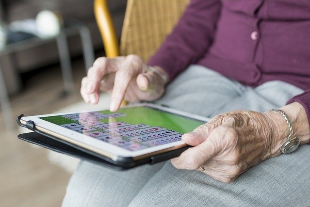 Anziana che gioca con il tablet